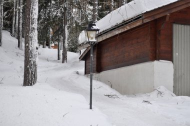 Kış aylarında köy evlerinin arka planında karlı bir dağ. Kışın dinlenmek için mükemmel bir yer..
