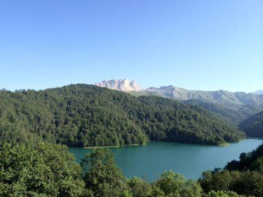 Dağlar arasında ormanlarla çevrili güzel mavi bir göl..
