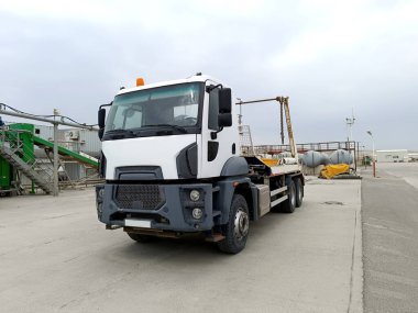 Fabrikadaki yükleyiciyi atla. Konteynırlar ve açık havada fabrikalarla çevrili bir kamyonet..