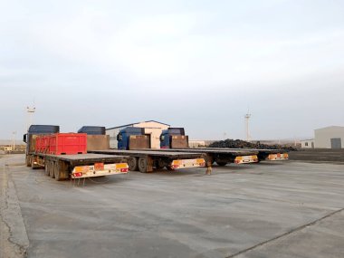 Tesiste karavanı olan bir kamyon sondaj çamuru ve petrol atıklarıyla dolu kırmızı atık yükünü bekliyor..