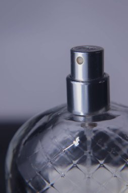 Beyaz ve siyah arkaplanlı parfüm şişesinin makro fotoğrafı.