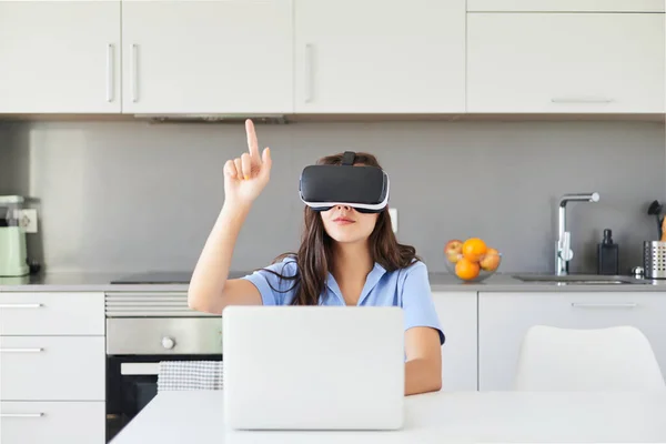 Young woman at home with VR goggles in the metaverse world. The concept of the metaverse, virtual reality, the future, technology and the internet of things.