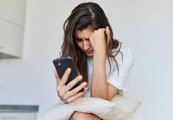 Young woman with anxiety problems due to mobile phone use. Mental health concept.