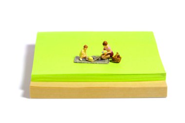 Yaratıcı minyatür insanlar oyuncak fotoğrafçılığı. Yapışkan notlar kurulumu. Bahçede aile pikniği, yaz tatilinde park. Beyaz arka planda izole edilmiş. Resim fotoğrafı.