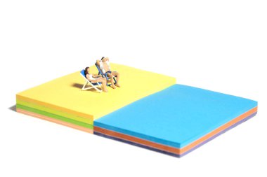 Yaratıcı minyatür insanlar oyuncak fotoğrafçılığı. Yapışkan notlar kurulumu. Sahildeki bankta takılan bir çift. Beyaz arka planda izole edilmiş. Resim fotoğrafı.