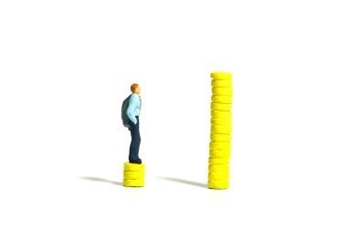 Minyatür minyatür insanlar oyuncak figürlü fotoğrafçılık. Maaş artışı ve boşluk kavramı. Para destesinin üzerinde duran bir iş adamı. Beyaz bir arka planda izole edilmiş. Resim fotoğrafı.
