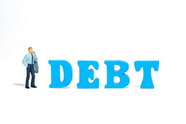 Minyatür minyatür insanlar oyuncak figürlü fotoğrafçılık. Borç tahtasının yanında duran stresli ve bunalımlı bir iş adamı. Beyaz bir arka planda izole edilmiş. Resim fotoğrafı.