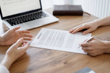 Ofisteki ahşap masada otururken sözleşmeyi imzalayan işadamları, yakın plan. Toplantıda ortaklar ya da avukatlar birlikte çalışıyor. Takım çalışması, ortaklık, başarı kavramı.