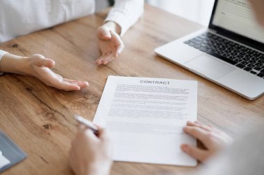 Ofisteki ahşap masada otururken sözleşmeyi imzalayan işadamları, yakın plan. Toplantıda ortaklar ya da avukatlar birlikte çalışıyor. Takım çalışması, ortaklık, başarı kavramı.