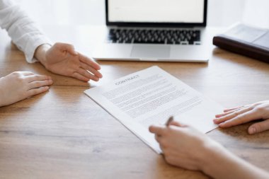 Ofisteki ahşap masada otururken sözleşmeyi imzalayan işadamları, yakın plan. Toplantıda ortaklar ya da avukatlar birlikte çalışıyor. Takım çalışması, ortaklık, başarı kavramı.