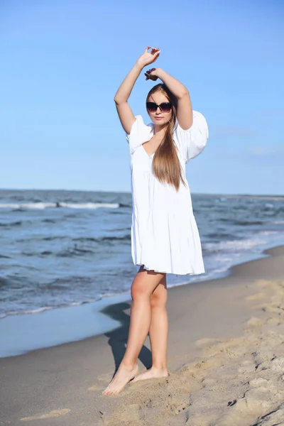 Šťastná Blondýna Žena Pláži Oceánu Bílých Šatech Slunečních Brýlích Zvedá — Stock fotografie