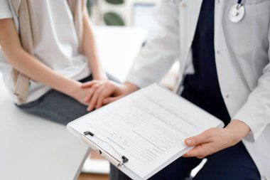 Doktor ve çocuk hasta. Hekim elinde bir dosya tutuyor ve bir çocuğu rahatlatıyor. Tıptaki ideal sağlık kavramı.