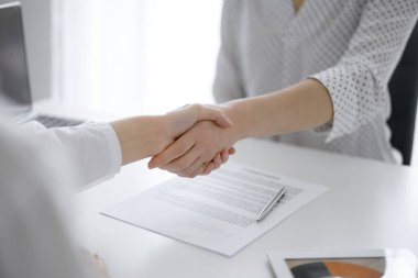 İş adamları anlaşma kağıtlarının üzerinde el sıkışıyorlar. Beyaz masaya yeni imzalanmış, yakın plan. Toplantıdaki avukatlar. Takım çalışması, ortaklık, başarı kavramı.