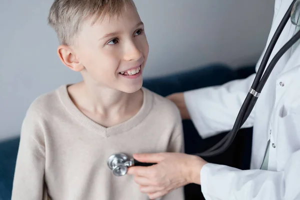 医師と幸せな笑顔の子供の少年患者が自宅の診察を受けました 医療コンセプト — ストック写真