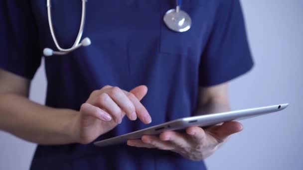 Mujer Doctora Usando Tableta Mientras Está Pie Cerca Fondo Gris — Vídeos de Stock