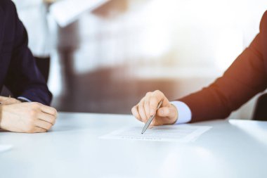 İş adamları, sözleşmeyi tartışanlar, toplantıda birlikte çalışanlar güneşli ve modern bir ofiste masa başında oturanlar. Meslektaşı olan isimsiz bir iş adamı, avukatlar görüşmede. Takım çalışması ve ortaklık