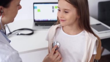 Doktor ve hasta. Mutlu gülümseyen kız çocuğu klinikte olağan sağlık kontrolünde. Tıp konsepti.