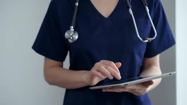 Mujer Doctora Usando Tableta Mientras Está Pie Cerca Ventana Panorámica — Vídeos de Stock