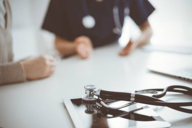 Steteskop arka planda bir doktor ve hastanın önünde tablet bilgisayarın üzerinde duruyordu. Tıp, sağlık hizmeti kavramı.