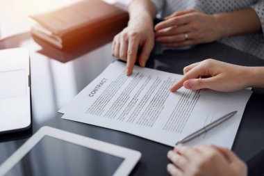 İş adamları ofiste cam masada otururken sözleşme imzalamayı tartışıyor, kapatıyorlar. Toplantıda ortaklar ya da avukatlar birlikte çalışıyor. Takım çalışması, ortaklık, başarı kavramı.