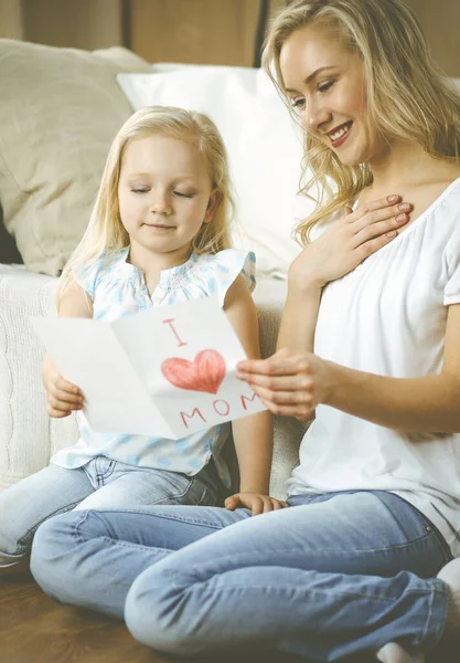 Anneler Günün kutlu olsun. Çocuk kızı annesini tebrik ediyor ve ona kalp çizimiyle kartpostal atıyor. Aile ve çocukluk kavramları.