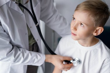 Doktor ve çocuk evde. Çocuk hasta her zamanki sağlık kontrolünde. Tıp, sağlık hizmetleri kavramları.