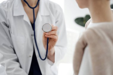 Doktor ve bir çocuk hasta. Doktor steteskop tutuyor ve çocuğu muayene etmeye hazır. Tıpta mükemmel sağlık kavramı.