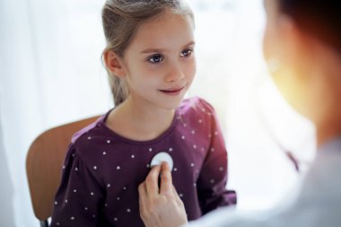 Her zamanki tıbbi muayenede gülümseyen çocuk hasta. Evde doktor ve çocuk hasta var. Tıp, sağlık hizmetleri kavramları.