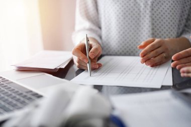 Müşteri ile vergileri sayıp tartışırken hesap makinesi ve dizüstü bilgisayar kullanan kadın muhasebeci. İş denetimi ve finans kavramları.