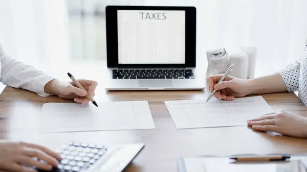 Два Бухгалтера Используют Ноутбук Калькулятор Подсчете Налогов Деревянном Столе Офисе — стоковое фото