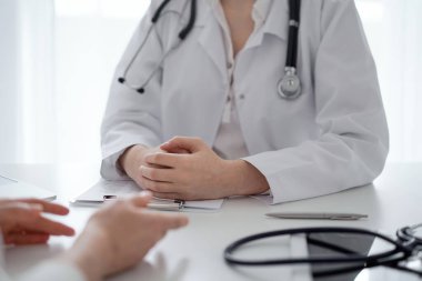 Doktor ve hasta klinikteki masada otururken sağlık sorularını tartışıyorlar. Kapatıyorlar. Tıp ve sağlık hizmetleri kavramı.