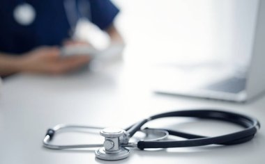 Steteskop arka planda bir doktor ve hastanın önünde tablet bilgisayarın üzerinde duruyordu. Tıp, sağlık hizmeti kavramı.
