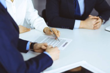 Bir grup iş adamı, erkek ve kadın, modern bir ofiste yapılan bir anlaşmanın detaylarını tartışırlar. Pazarlık ya da iş yerinde tartışırız. Takım çalışması, ortaklık ve iş konsepti.