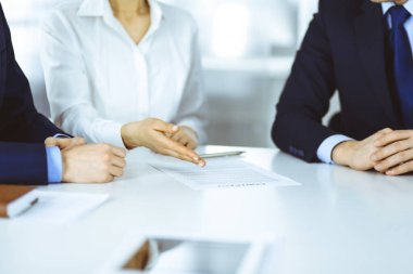 Bir grup iş adamı, erkek ve kadın, modern bir ofiste yapılan bir anlaşmanın detaylarını tartışırlar. Pazarlık ya da iş yerinde tartışırız. Takım çalışması, ortaklık ve iş konsepti.