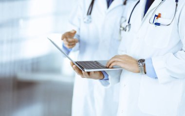 Steteskoplu kimliği belirsiz iki doktor hastane ofisinde dururken tıbbi muayene sonuçlarını tartışıyor. Doktorlar ilaç isimlerini kontrol etmek için dizüstü bilgisayar kullanıyorlar. İlaç ve sağlık hizmetleri