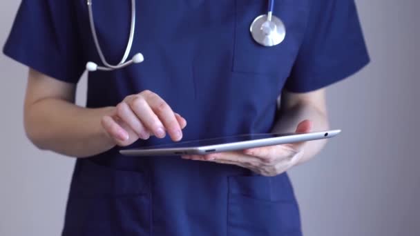Médica Mulher Usando Computador Tablet Enquanto Está Perto Fundo Cinza — Vídeo de Stock