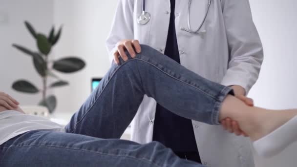Lekarz Pacjent Klinice Ortopeda Białym Płaszczu Bada Staw Kolanowy Kłamliwej — Wideo stockowe