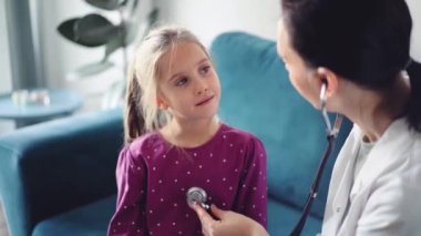 Her zamanki tıbbi muayenede gülümseyen çocuk hasta. Evde doktor ve çocuk hasta var. Tıp, sağlık hizmetleri kavramları.