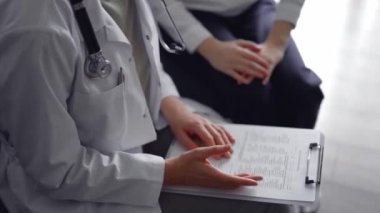 Doktor ve hasta mavi bir kanepede yan yana otururken bir şeyler tartışıyorlar. Tıp konsepti.