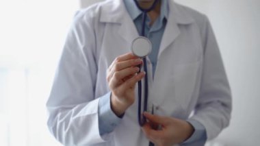 Doktor steteskopunu tutar ve hastayı muayene etmek için ileri alır. Profesyonel sağlık hizmeti hizmeti konsepti, tıp.