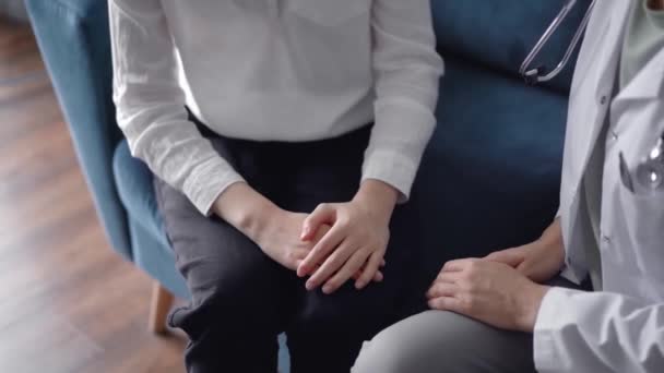 医師は 座って青いソファーで互いの近くで何かを話し合っている間 患者を安心させる 医学コンセプトにおける共感 — ストック動画