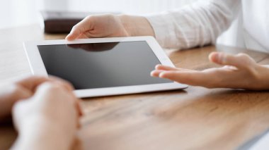 Sözleşme belgeleri ahşap masada yatarken iş adamları arka plandaki ahşap masada bir şey tartışıyorlar. Takım çalışması, ortaklık, sözleşme imzalama kavramı.