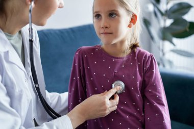 Çocuk hasta her zamanki sağlık kontrolünde. Evde doktor ve çocuk hasta var. Tıp, sağlık hizmetleri kavramları.