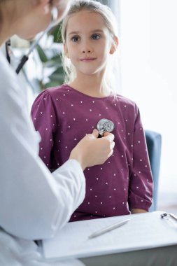 Her zamanki tıbbi muayenede gülümseyen çocuk hasta. Evde doktor ve çocuk hasta var. Tıp, sağlık hizmetleri kavramları.