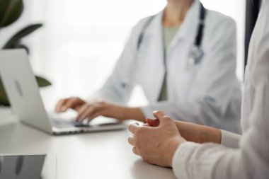 Doktor ve hasta klinikteki masada otururken sağlık muayenesini tartışıyorlar. Mükemmel tıbbi hizmet ve tıp konsepti.