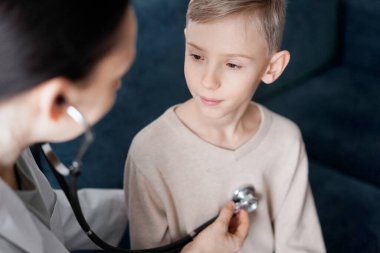 Doktor ve çocuk hasta evde sağlık kontrolünde. Tıp, sağlık hizmetleri kavramları.