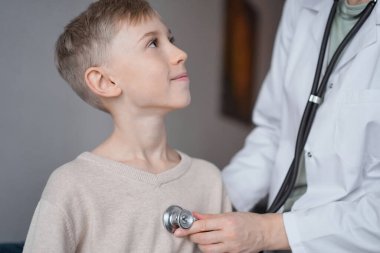 Doktor ve mutlu gülümseyen çocuk hasta ev sağlık kontrolünde. Tıp, sağlık hizmetleri kavramları.