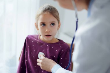 Çocuk hasta her zamanki sağlık kontrolünde. Evde doktor ve çocuk hasta var. Tıp, sağlık hizmetleri kavramları.