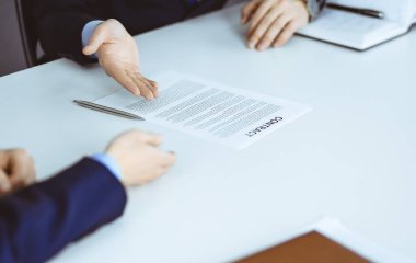 İş adamları, modern bir ofiste masa başında oturan bir sözleşmeyi tartışıyor. Meslektaşı olan isimsiz bir iş adamı, avukatlar görüşmede. Takım çalışması ve ortaklık kavramı.