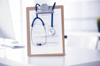 Stetoskop ve ilaç geçmişi olan dosya doktorların çalışma yerinde masanın üstünde. İlaç ve sağlık hizmetleri kavramı.